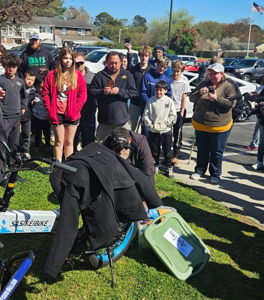 Austin kneels overwhlemed by emotions as he tries to process the donations presented to him from the community